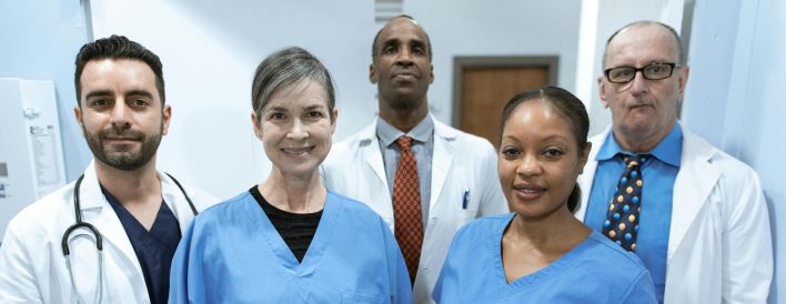 Group of diverse healthcare professionals posing confidently indoors.